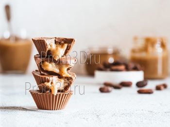 Stack of vegan chocolate cups with caramel on white